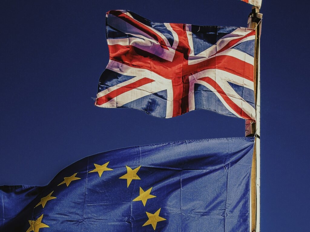 Flag of the UK flying above that of the EU as a techUK report warns the government must act to maintain semiconductor industry leadership to deliver economic growth, support its wider industrial strategy, and match global investments like the European Chips Act.