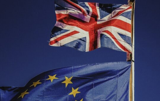 Flag of the UK flying above that of the EU as a techUK report warns the government must act to maintain semiconductor industry leadership to deliver economic growth, support its wider industrial strategy, and match global investments like the European Chips Act.