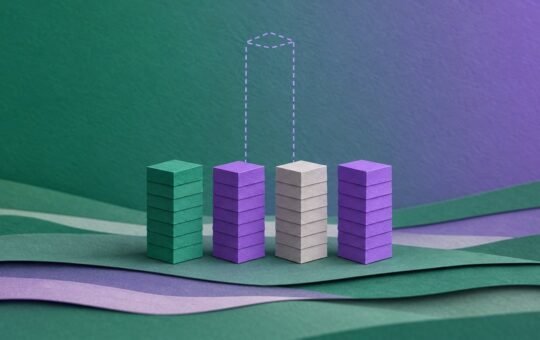Four layered paper towers of similar height stand in a row, with a dashed outline showing where a much taller fifth tower once stood.